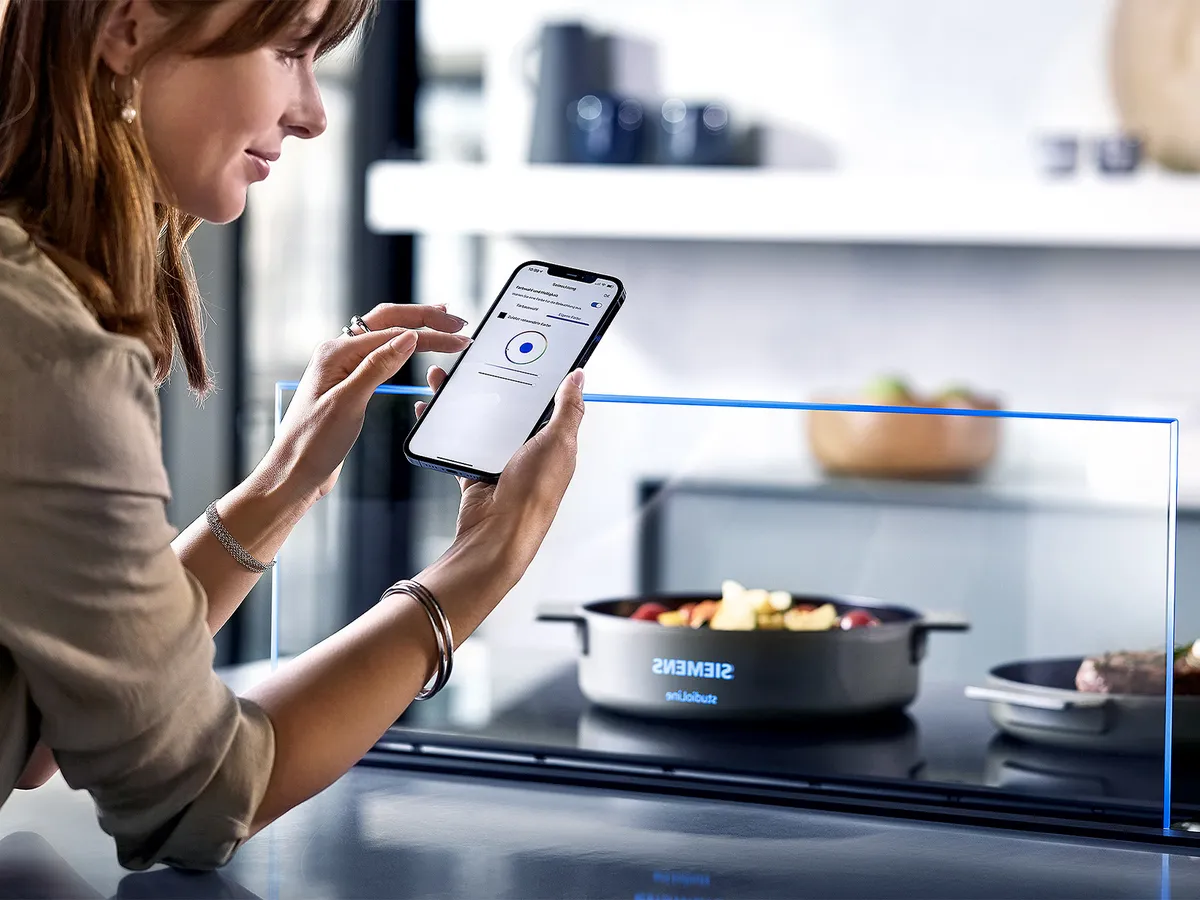 Person using home connect app to control hood settings