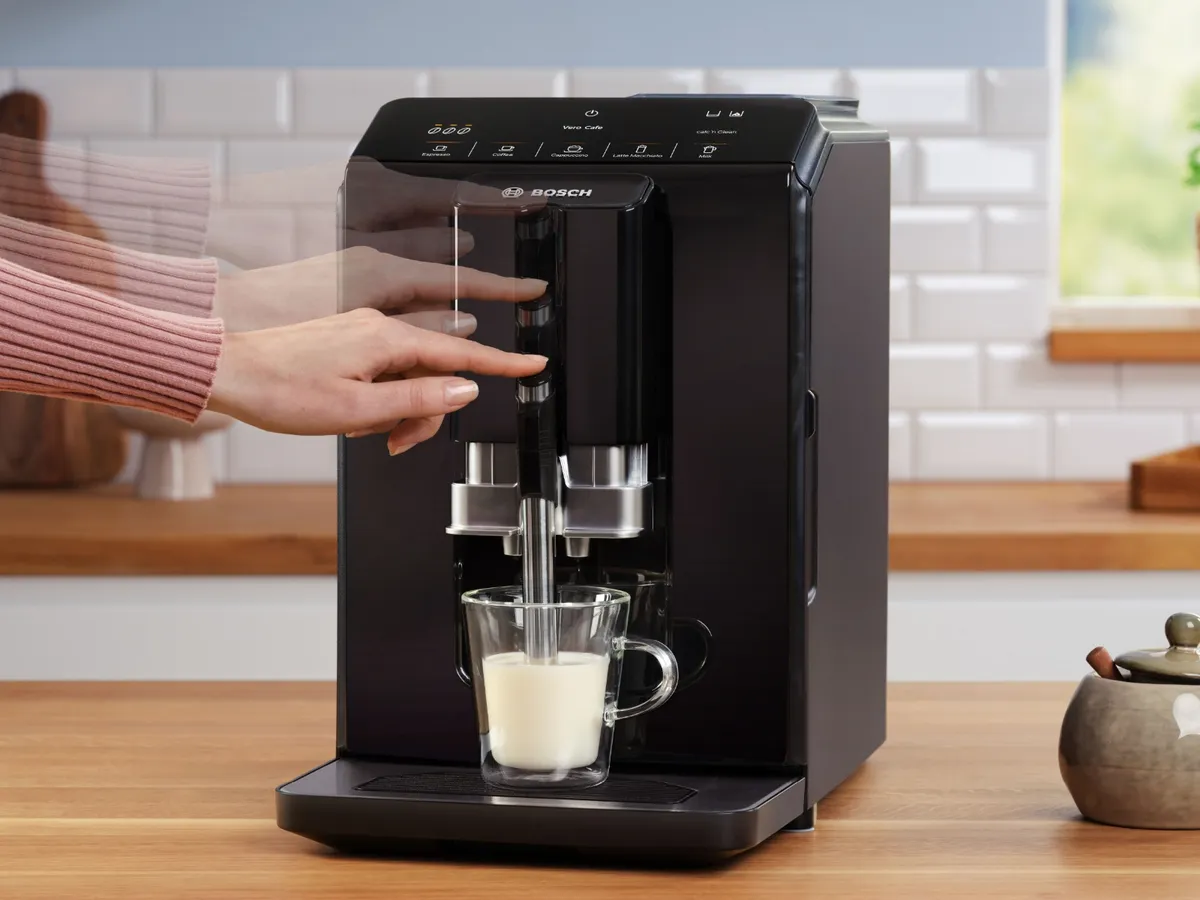 Person pressing touch display of Series 8 VeroCafe machine and European flag in image top corner.