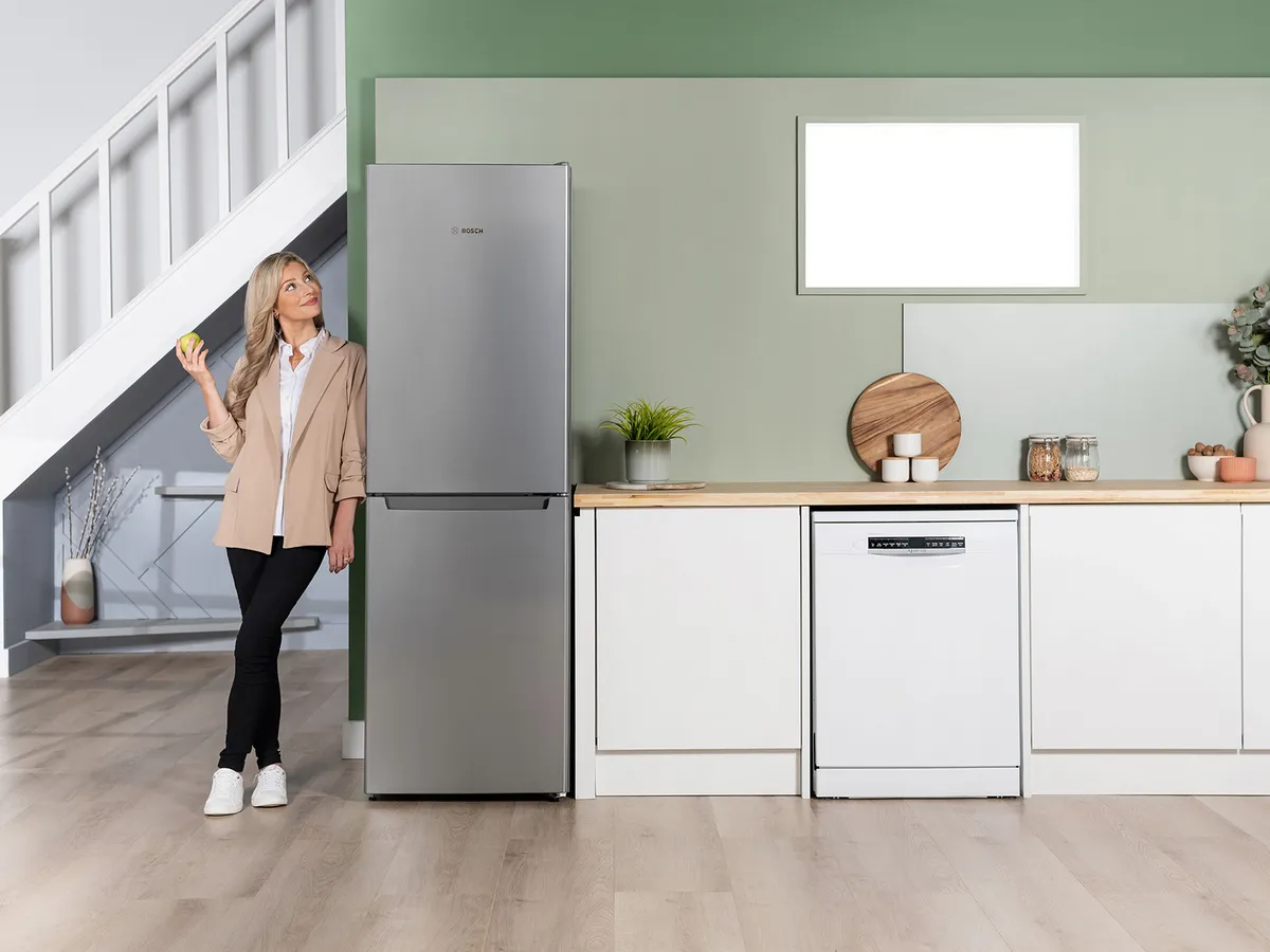 Person stood next to fridge freezer