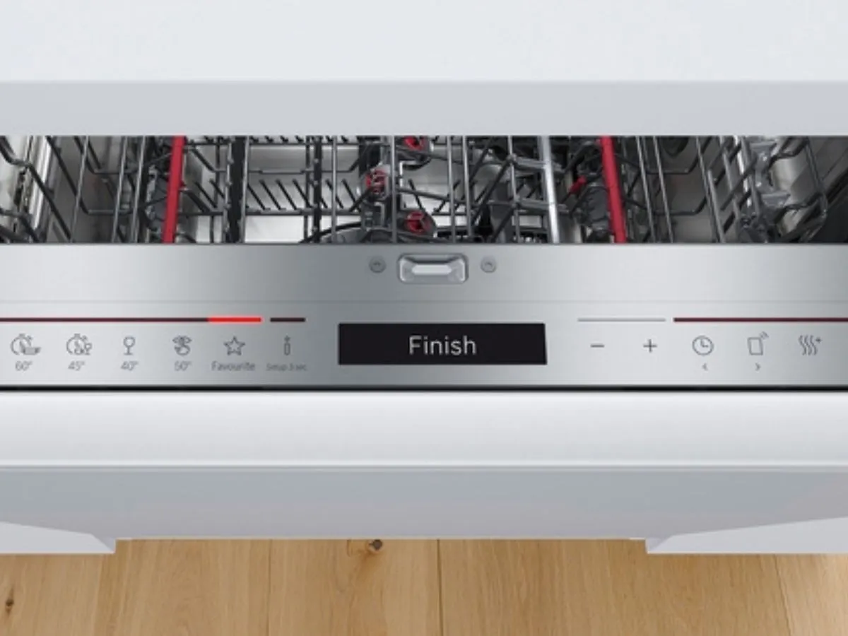 A modern kitchen corner featuring a Bosch dishwasher, minimalist sink, and a cookbook.
