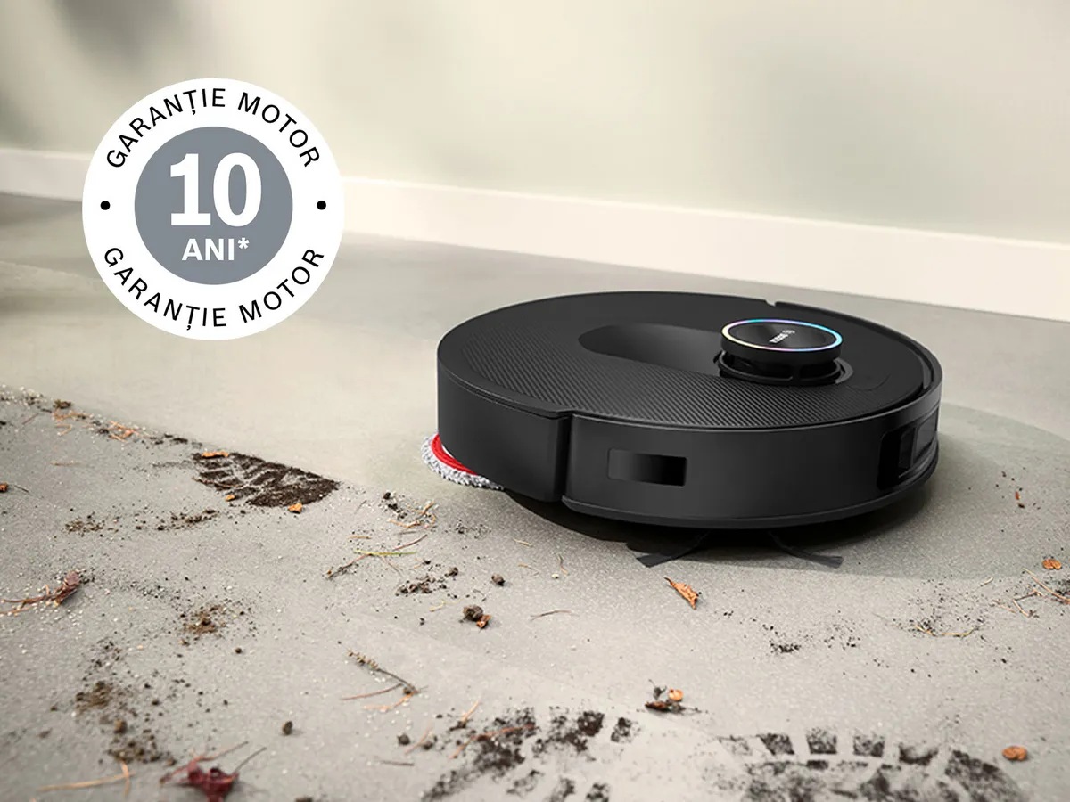 Spotless curăță noroiul de pe gresia albă, în colțul din stânga sus este aplicat logo cu garanția de 10 ani pentru motor.