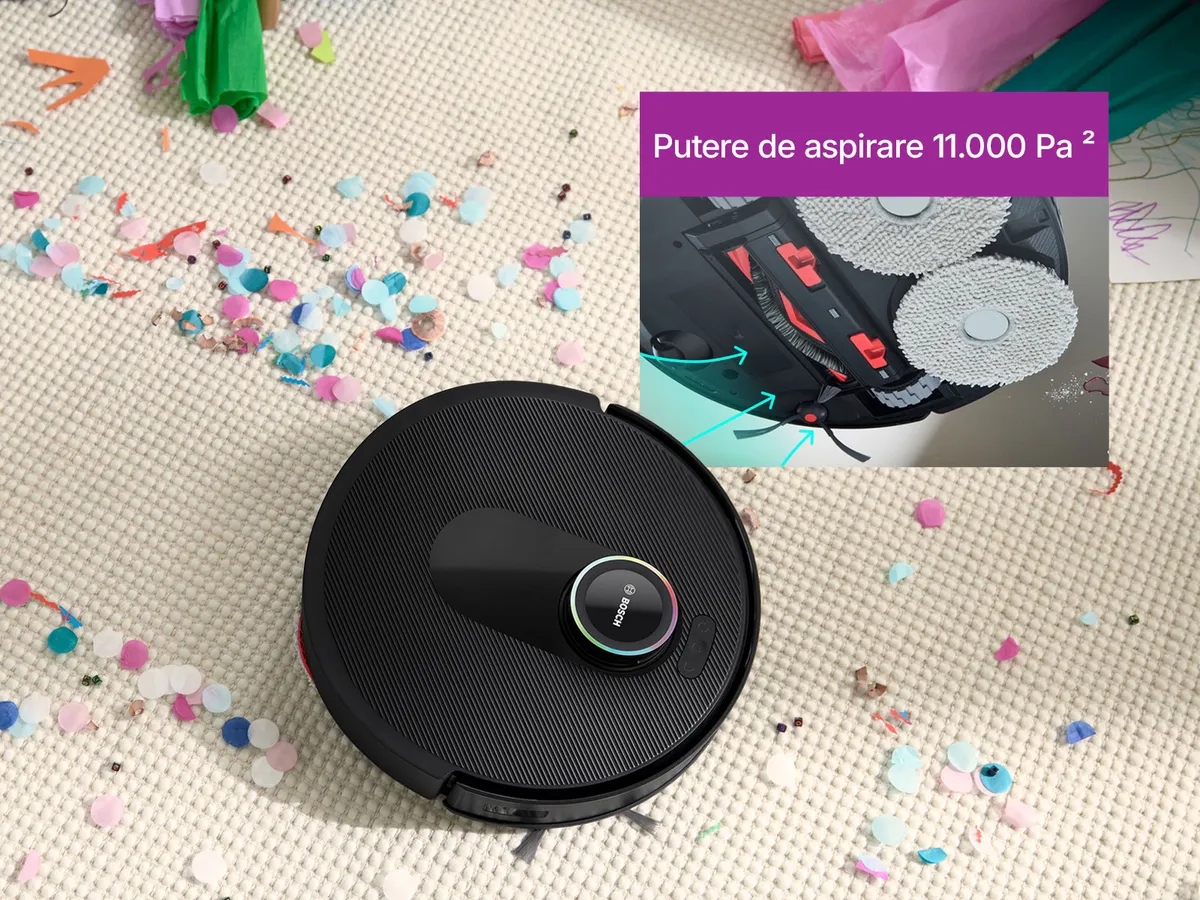 Spotless pe un covor alb, curățând o cale prin confetti, evidențiind puterea sa de aspirație.