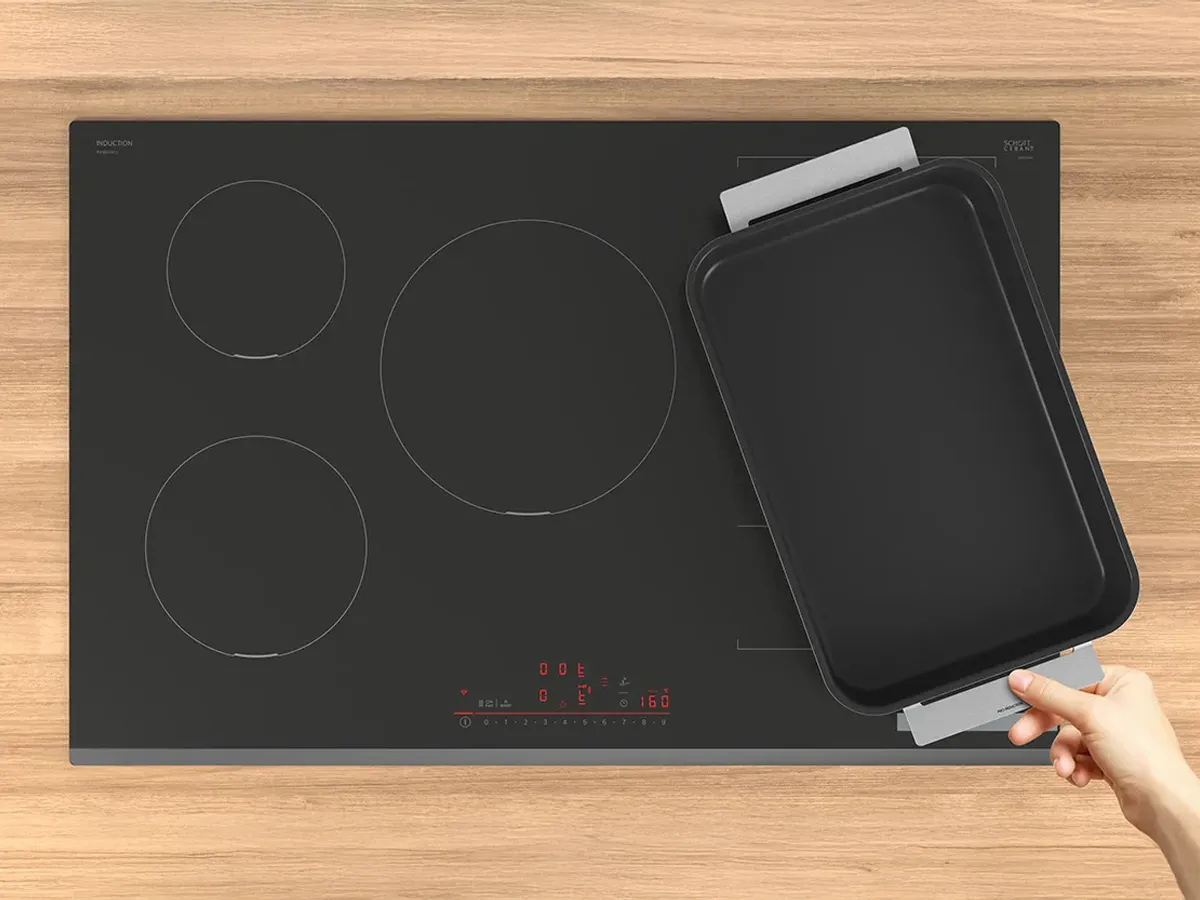 Steak and shrimp cooked on different zones of a hob all at once.