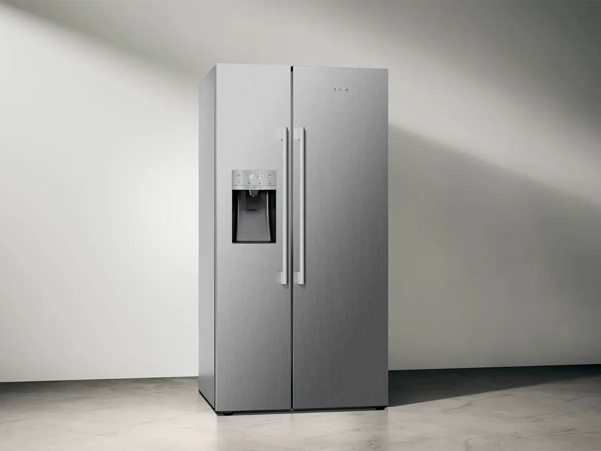 Schlanker, moderner Side-by-Side Kühlschrank mit Wasserspender, in einem minimalistischen Raum.