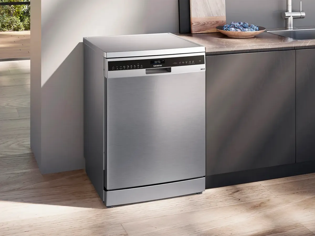 Silver freestanding Siemens dishwasher with modern kitchen in the background.