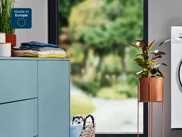 Moderne Küche mit Waschmaschine, Trockner und Wäschekorb.