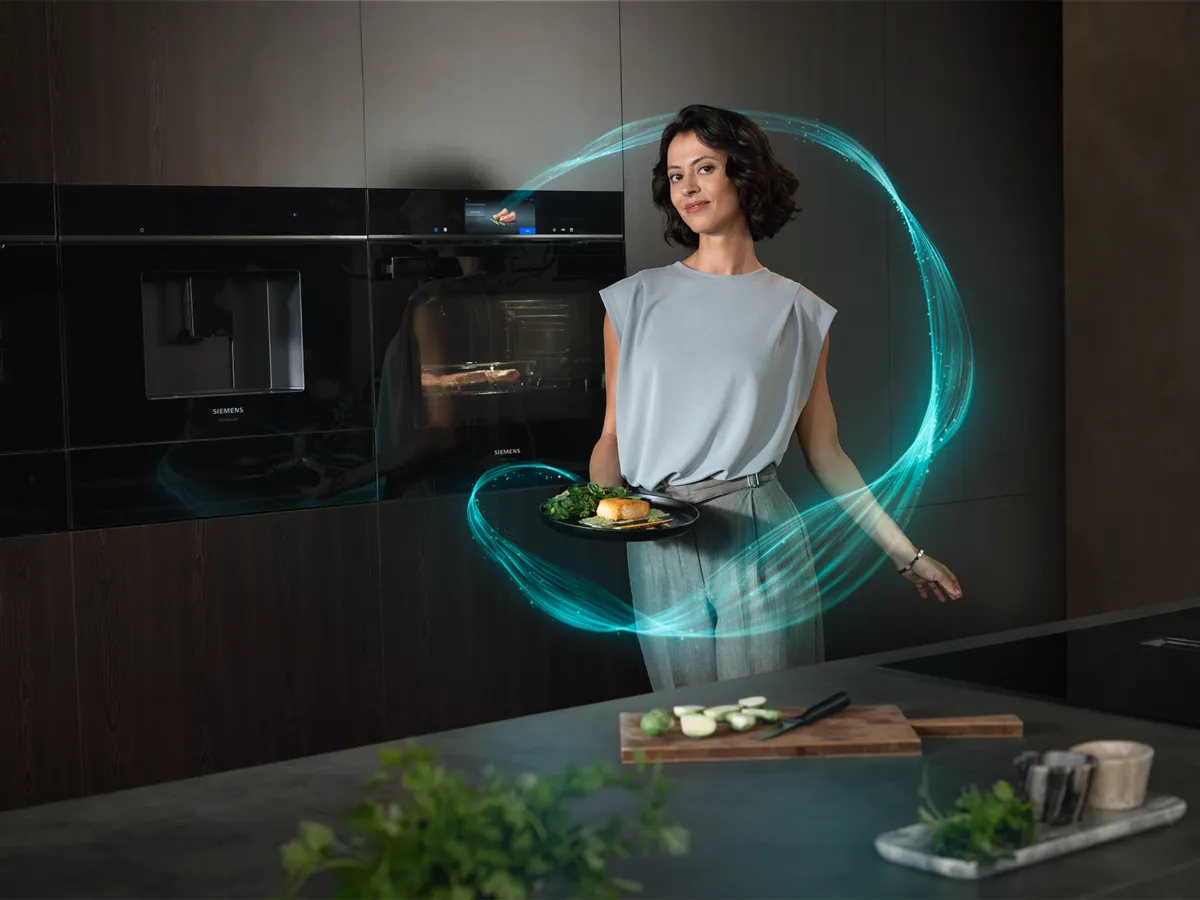 In a modern kitchen, a person holds a plate of food amidst a futuristic glowing design, complemented by sleek appliances in the background.
