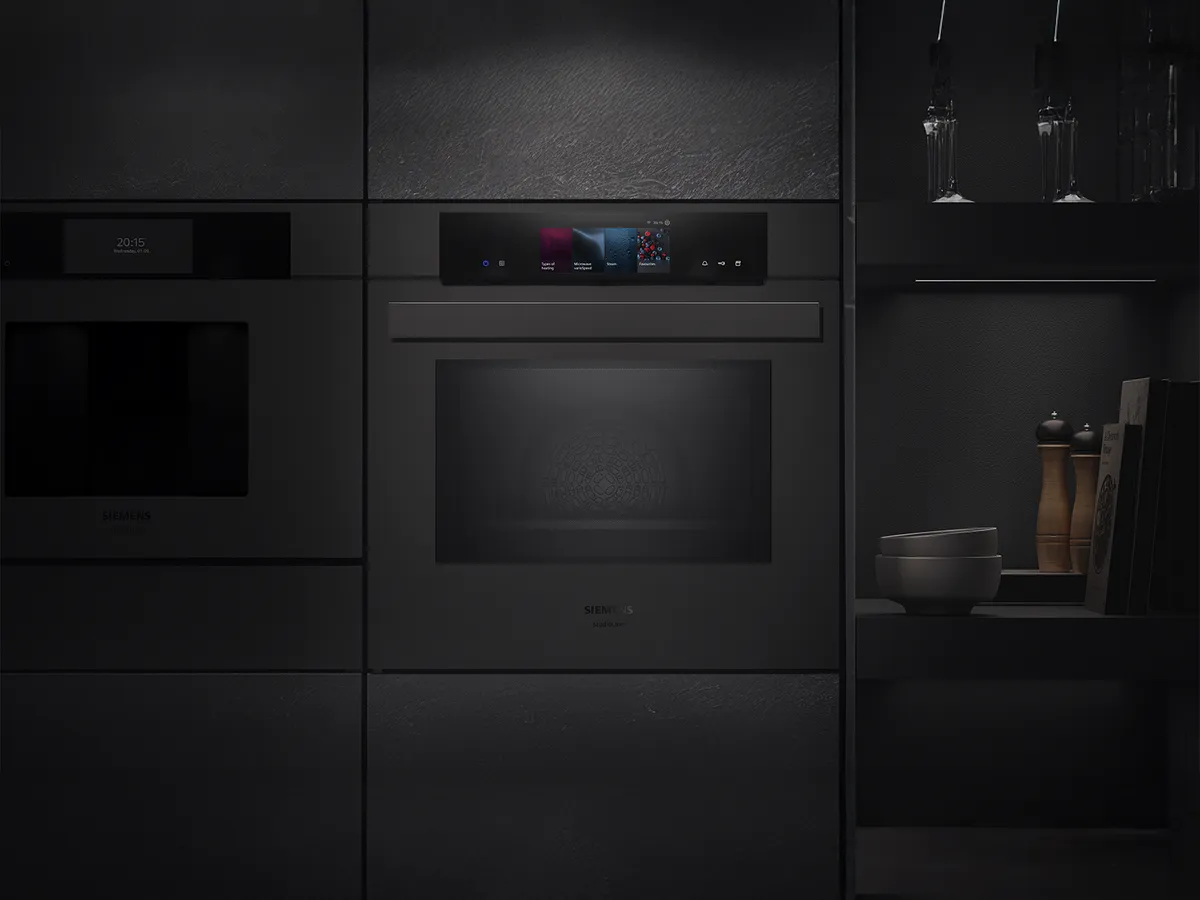 A sleek black Siemens oven integrated into modern cabinetry, featuring a touchscreen control panel and ambient lighting.