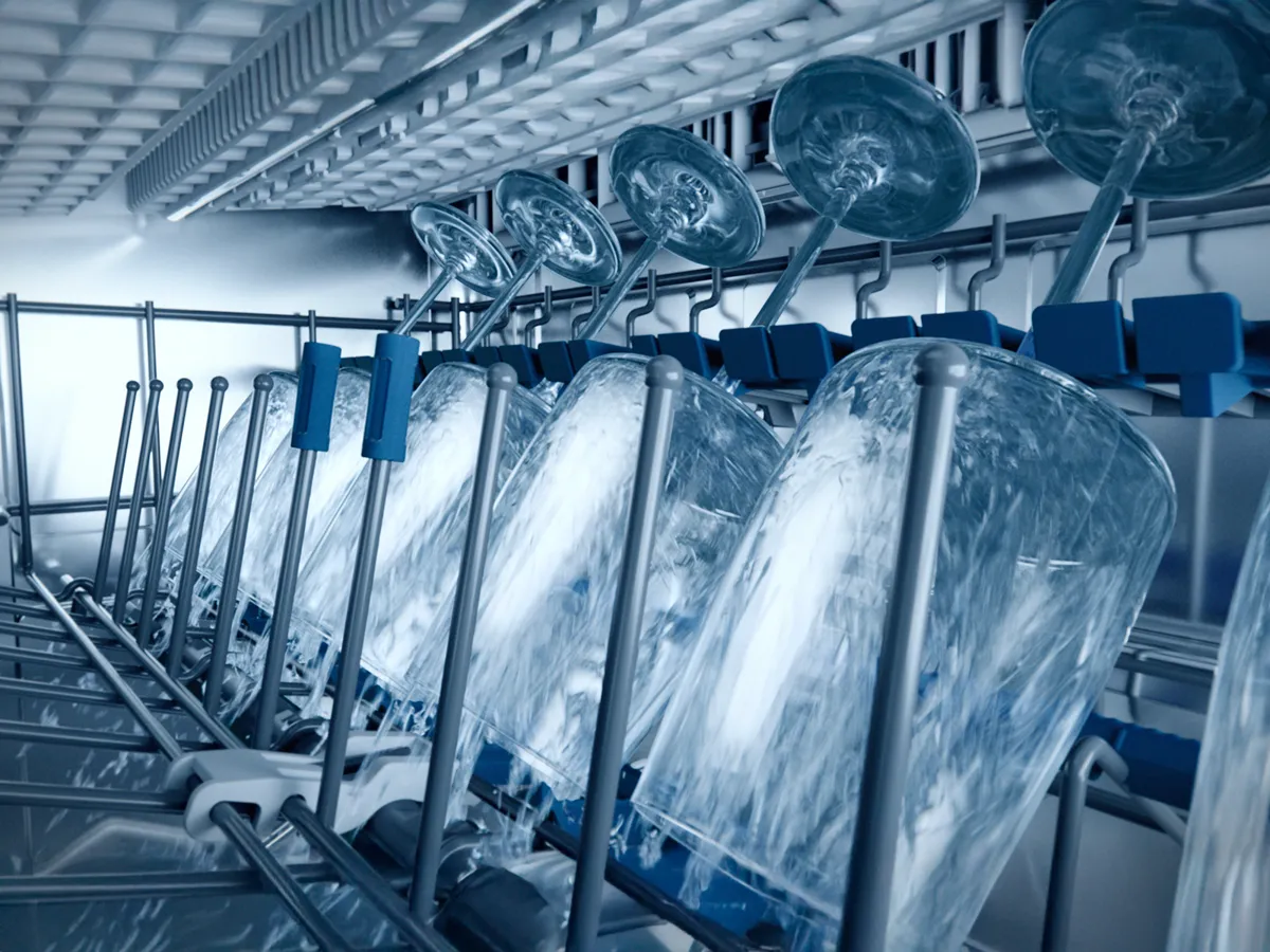 Dishwasher racks with water jets, industrial kitchen equipment, commercial cleaning appliance.