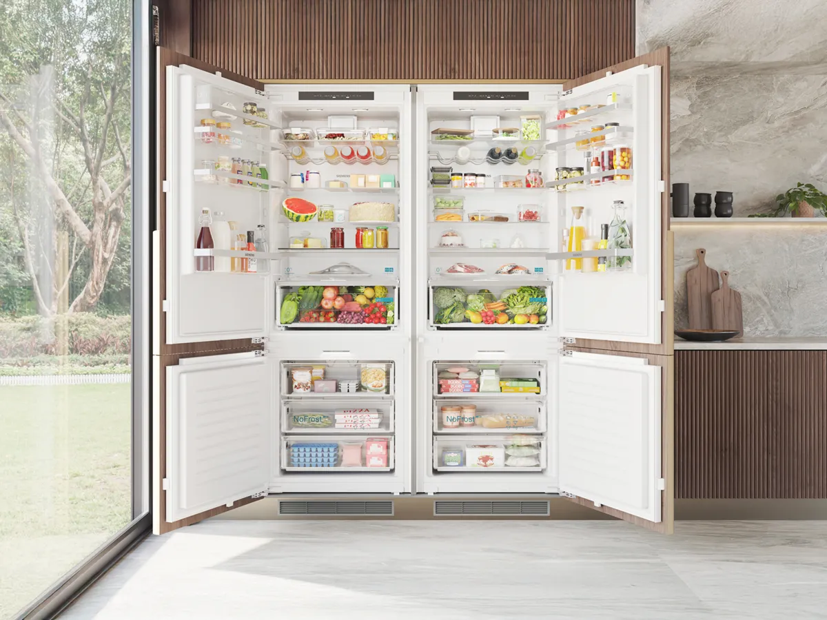 Open double-door fridge filled with various foods and drinks, set in a modern kitchen.
