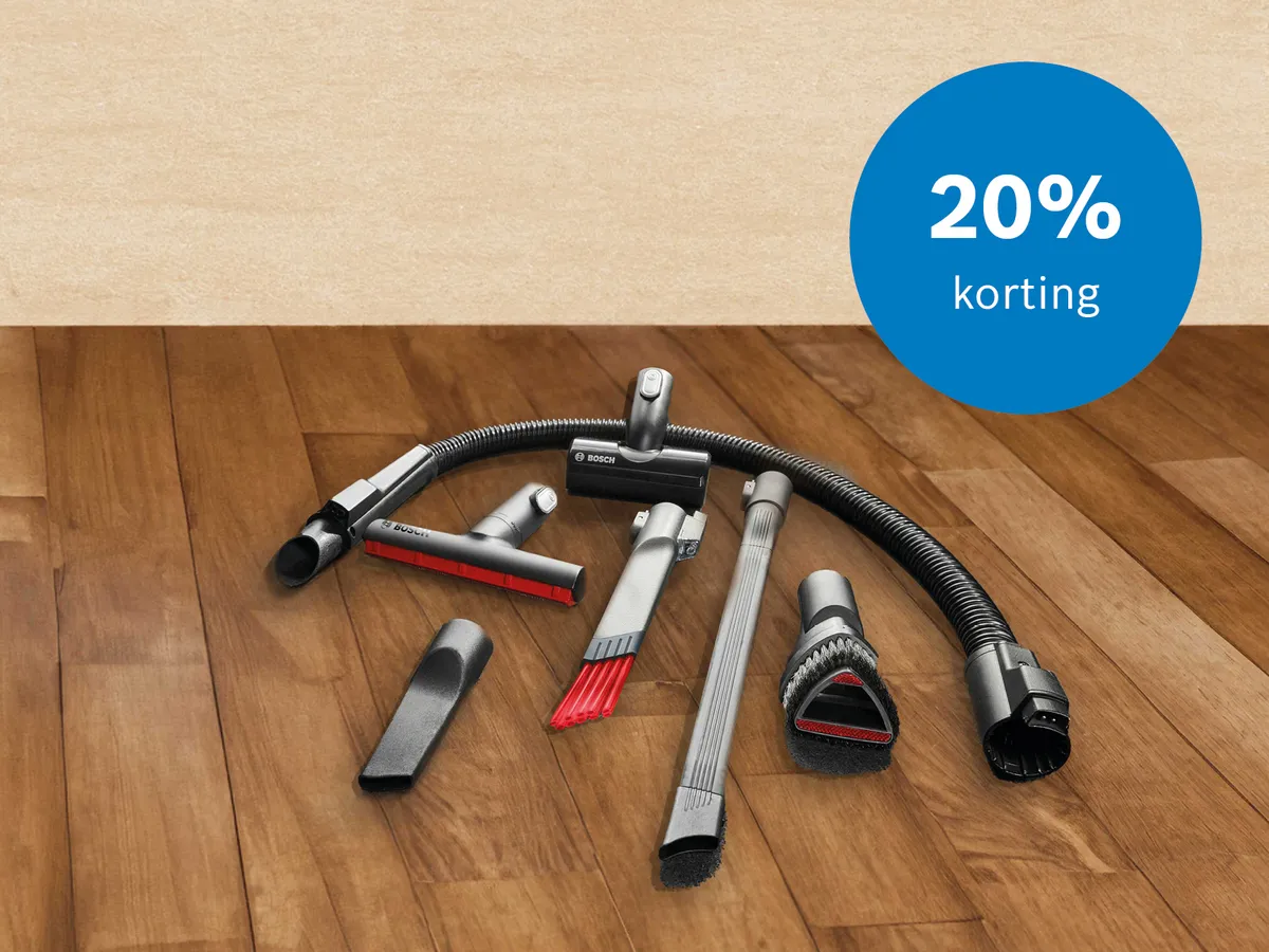 Bosch stofzuigeraccessoires uitgespreid op houten vloer naast stofzakken 