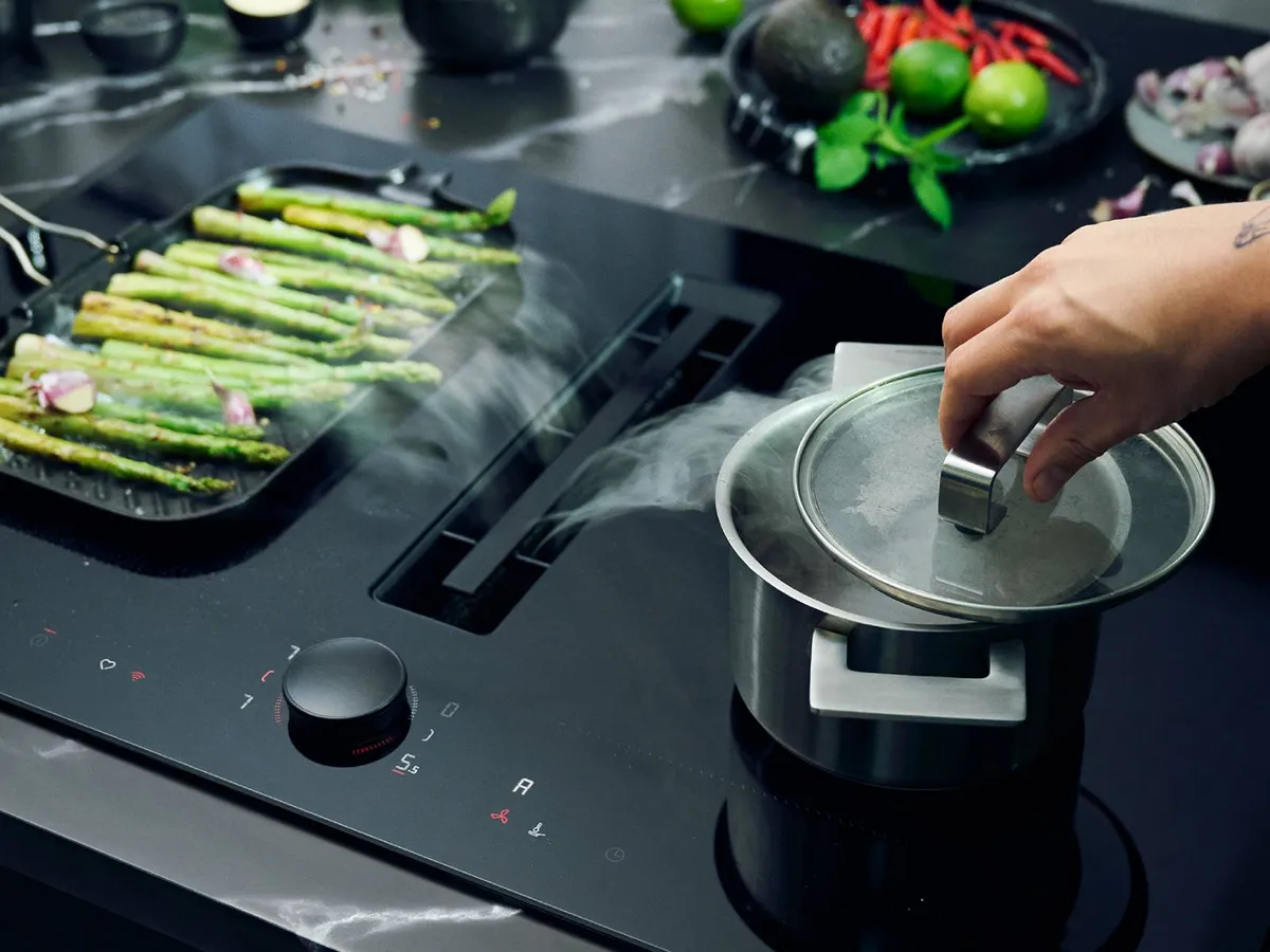 Venting hob extracting steam from two pans cooking