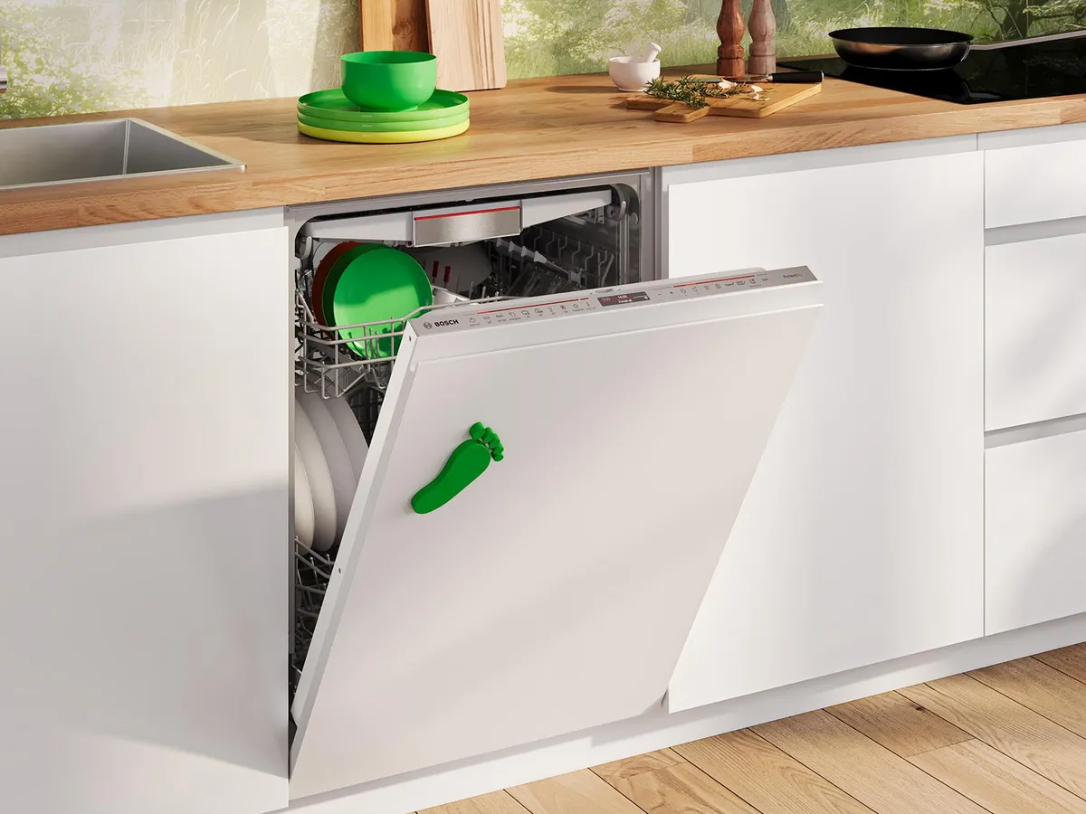 Otwarta zmywarka Bosch w jasnej kuchni, załadowana naczyniami i miskami.