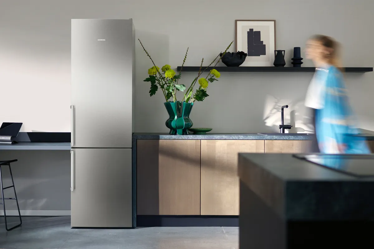 Lodówka wolnostojąca w eleganckiej kuchni, obok kobieta