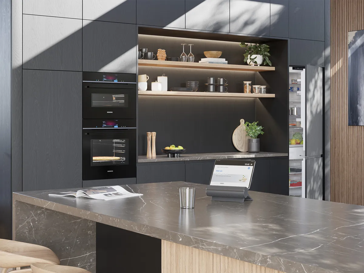 Contemporary kitchen with dark wood cabinets, two Siemens ovens, a marble island with a tablet, and an open refrigerator.