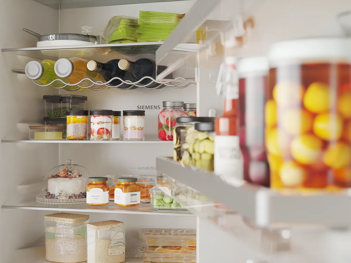A neatly organized refrigerator showcasing colorful bottles, jars of preserved fruits, vegetables, and various packaged foods.