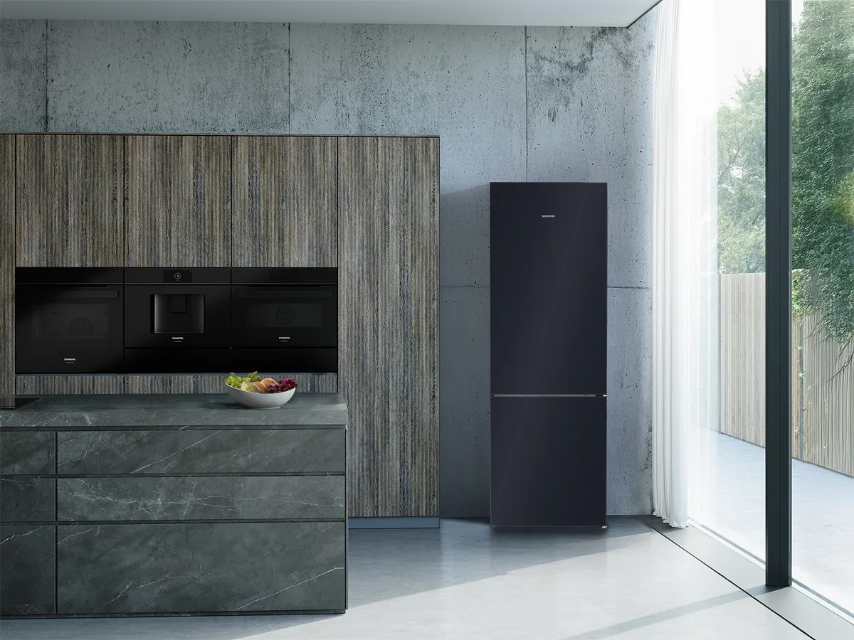 A modern kitchen with dark wood cabinets, built-in appliances, a black refrigerator, and a large window.
