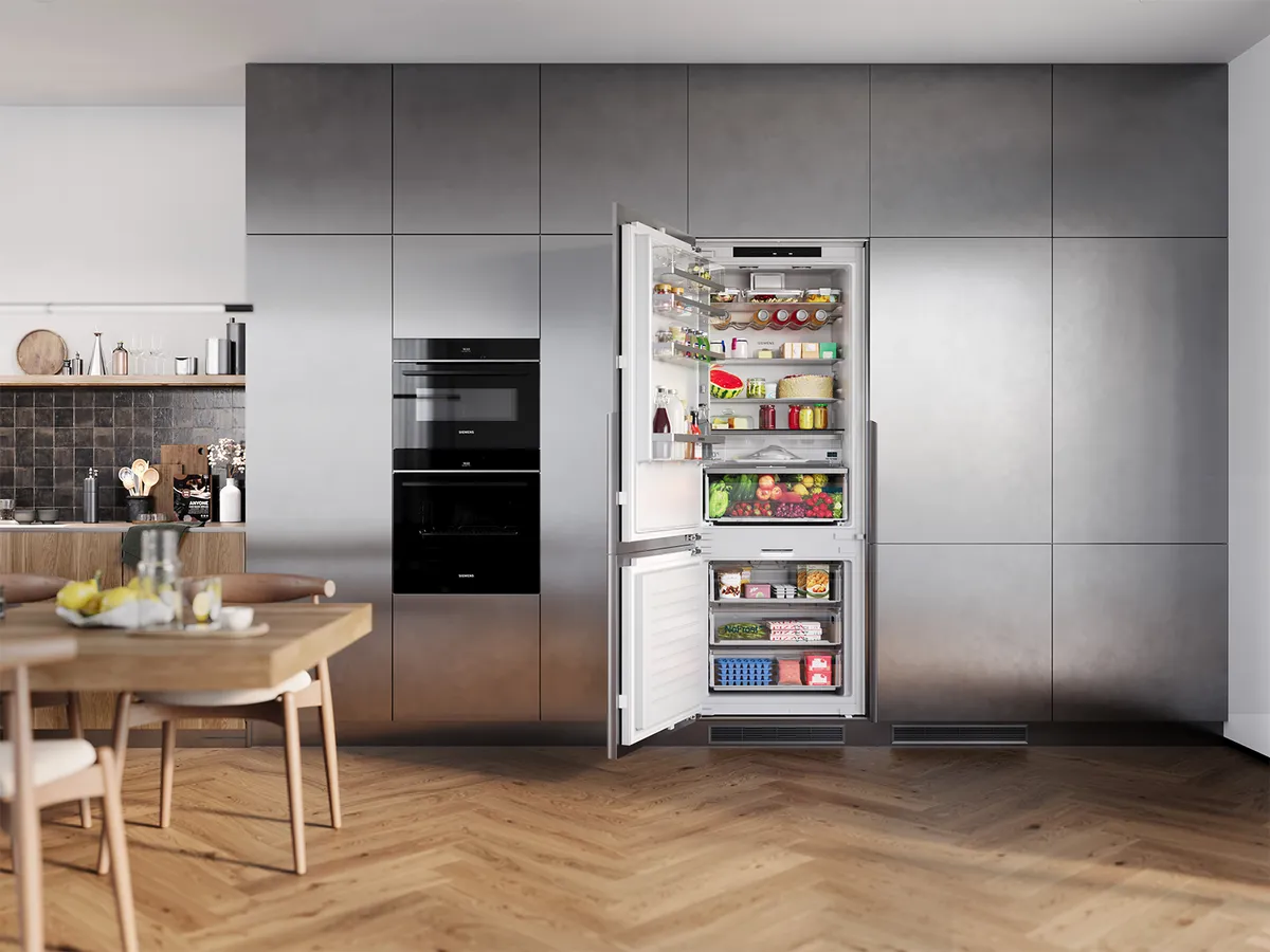 A modern kitchen displaying a stainless steel refrigerator, stocked with fresh produce and jars, next to an elegant wooden dining table.