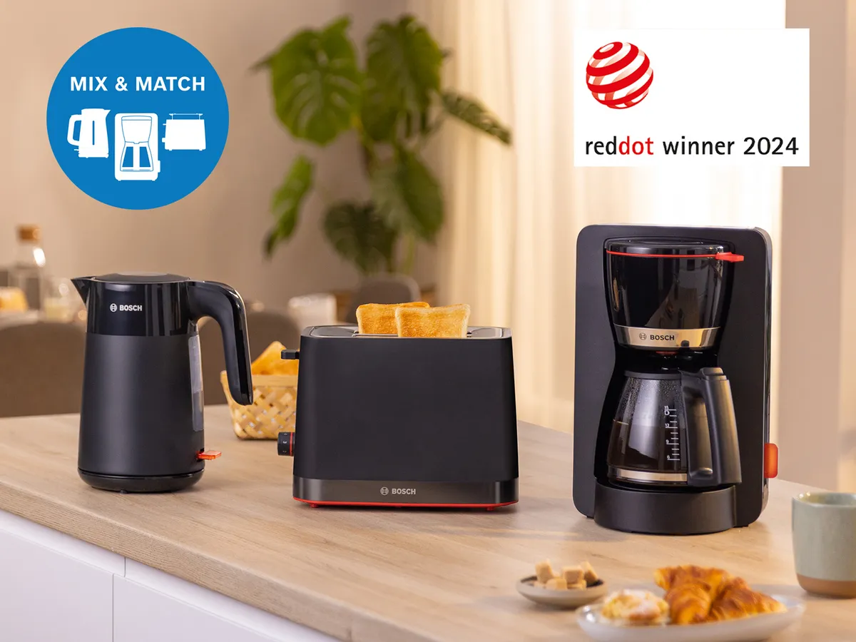 Bosch Frühstücksset: Wasserkocher, Toaster und Filterkaffeemaschine auf der Holzküchenarbeitsplatte – umgeben von kleinen Speisen.