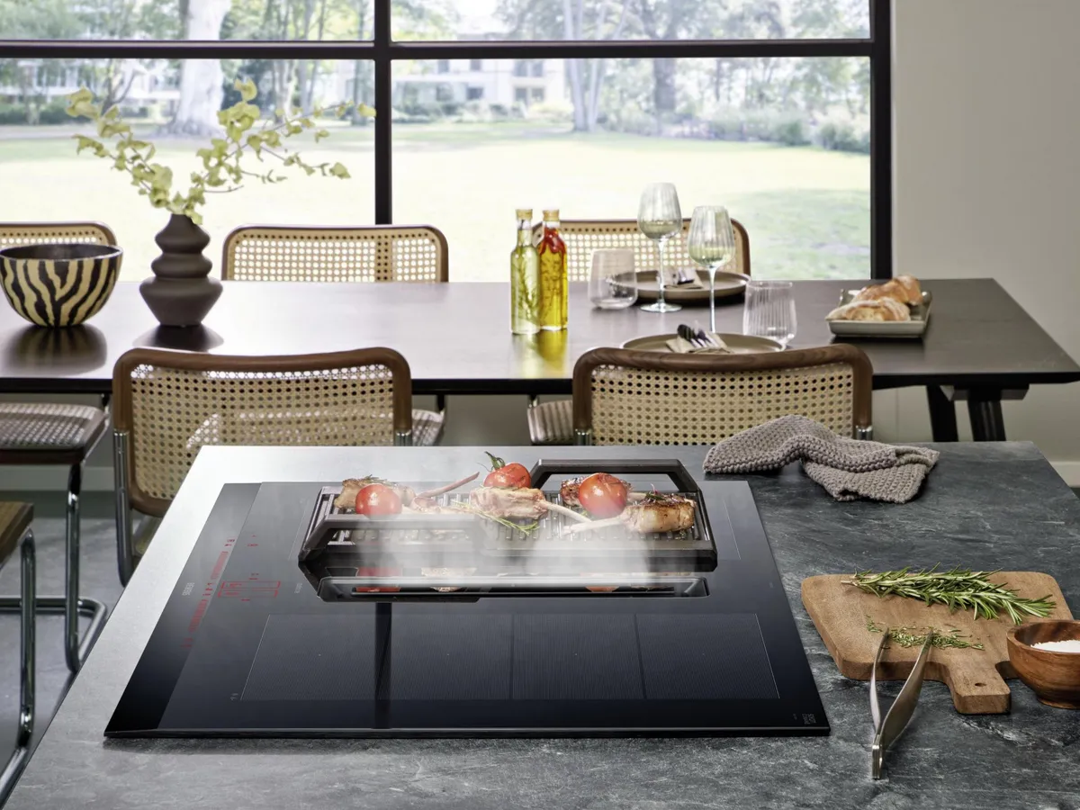 El extractor integrado en una placa de inducción Siemens absorbe el vapor emitido por la cocción de una cacerola de acero