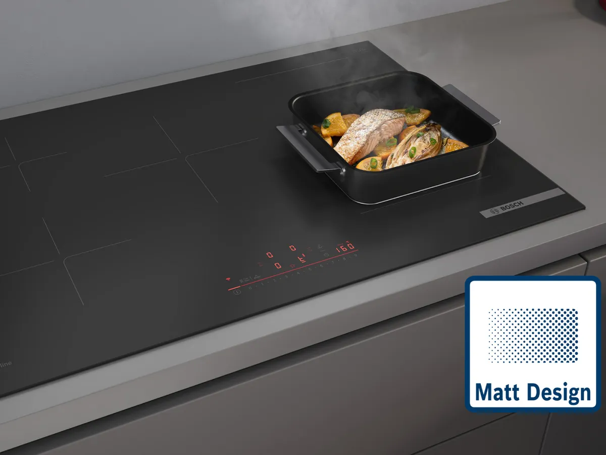 Bosch accent line Induktionskochfeld im Matt Design, flächenbündig eingebaut, mit Bräter und Fischfilet – elegante matte Glasoberfläche.