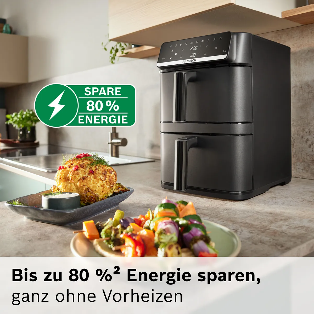 Bosch Doppel-Schubladen-Heißluftfritteuse auf Küchenarbeitsplatte mit geröstetem Essen, betont "SPARE 80% ENERGIE" und kein Vorheizen.