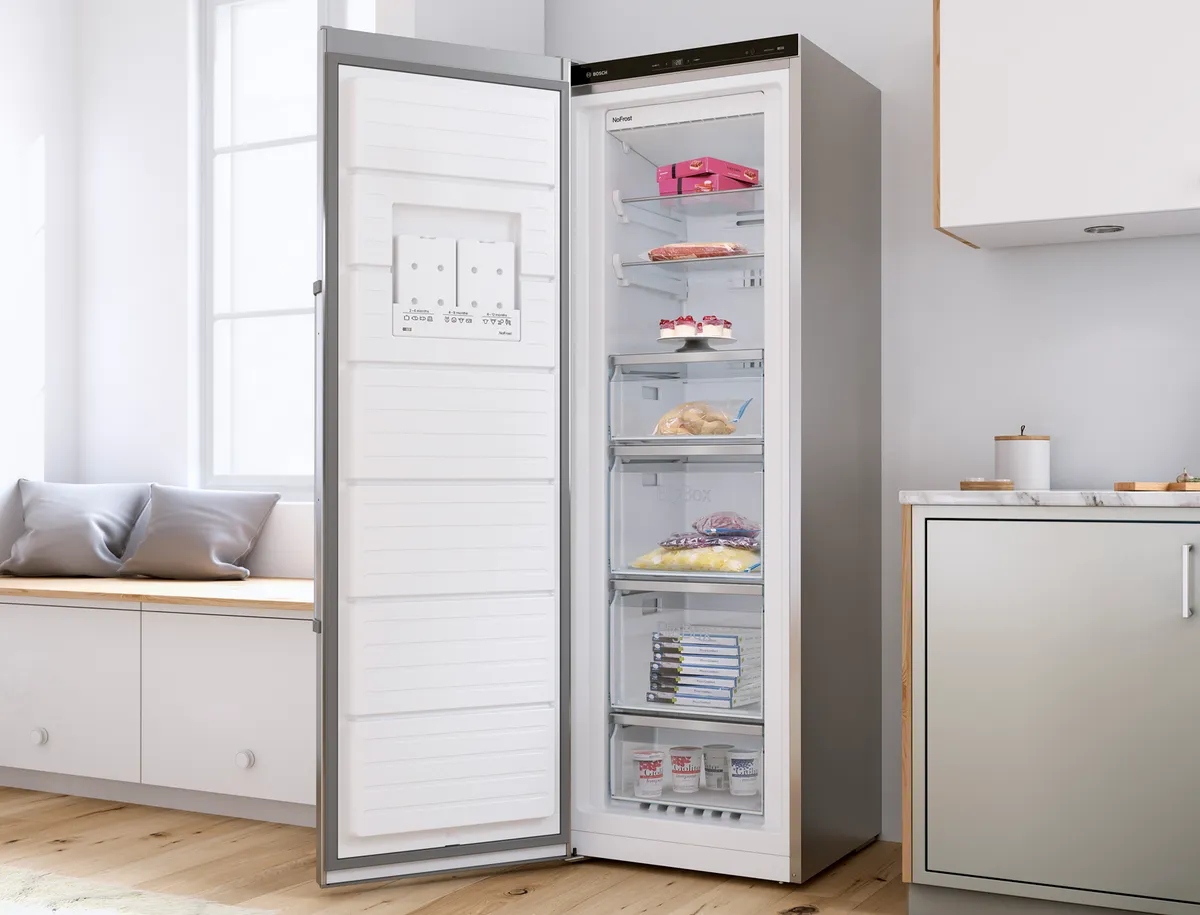 Modern kitchen with open refrigerator displaying various food items.