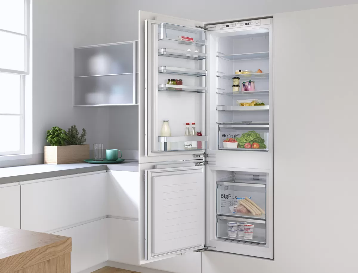 Modern kitchen with open refrigerator displaying various food items and kitchen accessories.