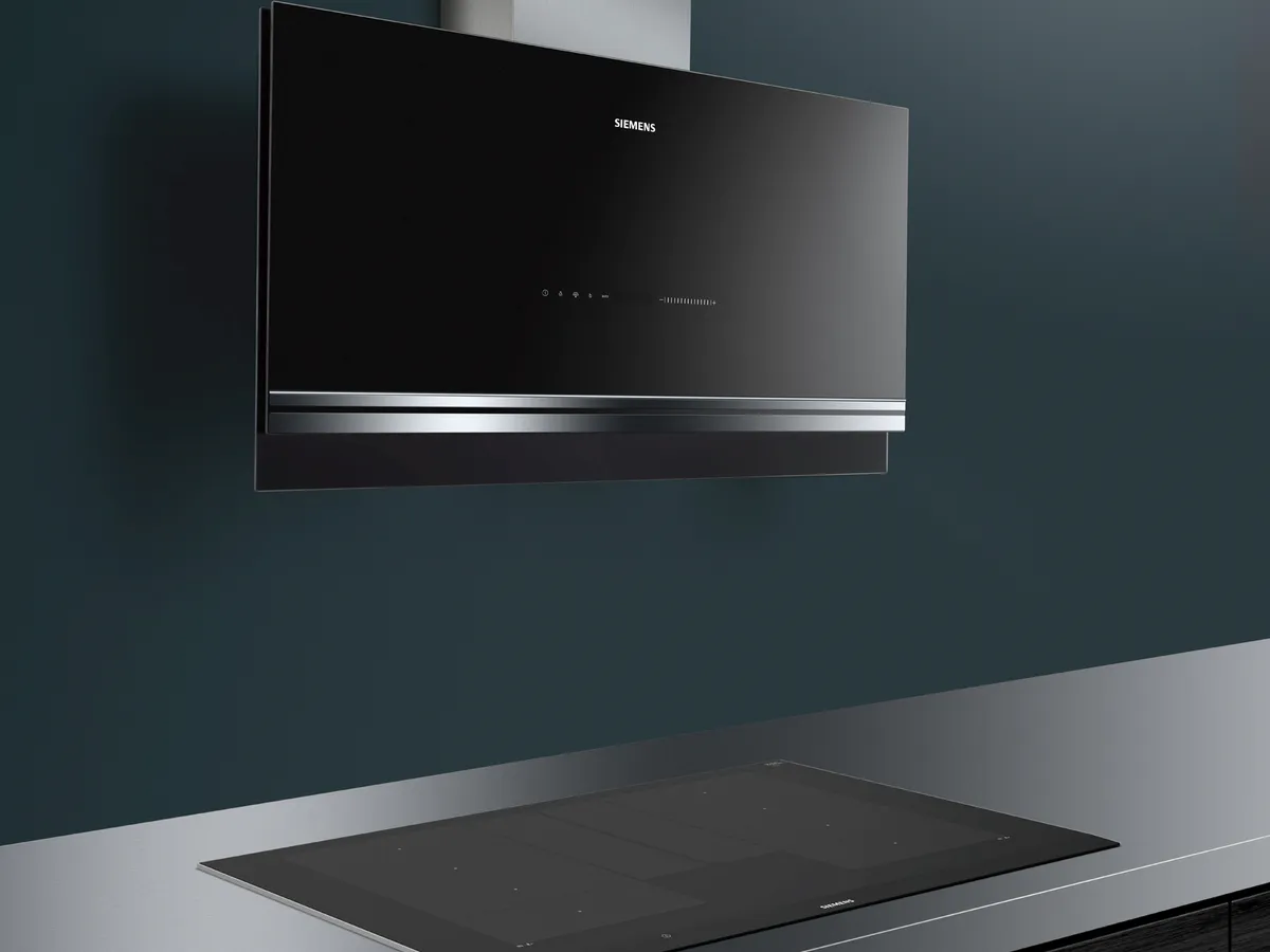 Duvar kaplı siyah mutfak aralığı hood ve indüksiyon koyu arka plan üzerinde.