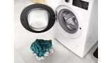 Bosch Waschmaschine mit ge&ouml;ffneter T&uuml;r und kleinem W&auml;scheberg davor