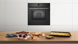 Ein 60&nbsp;cm breiter Bosch Backofen mit einem blauen Ma&szlig;band zur Veranschaulichung der Gr&ouml;&szlig;e.