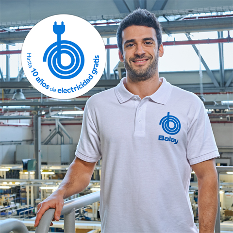 Hombre sonriente con polo Balay en f&aacute;brica, junto a un logo circular de enchufe que anuncia "Hasta 10 a&ntilde;os de electricidad gratis".