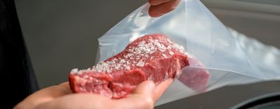 Steak mit grobem Salz, das in einen Beutel zum Vakuumieren für das Dampfgaren gegeben wird. 