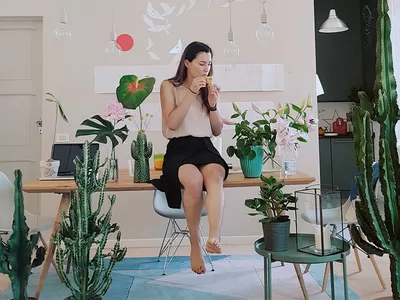 A woman sitting on a table with flower pots