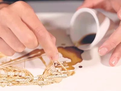 Artistic coffee design in progress, showcasing a creative coffee spill on textured paper.