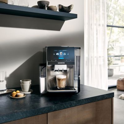Fully automatic espresso machine displayed on a countertop in a modern kitchen setting. 