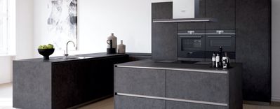 Eine moderne grifflose schwarze Küche mit Siemens Einbaubacköfen und Sous-vide-Backofen.