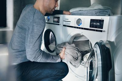 Man using home connect to control washing machine