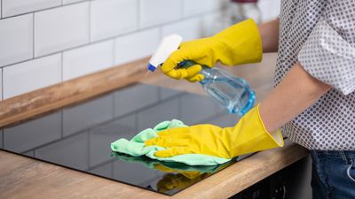 Osoba w rekawiczkach czysci plyte indukcyjna