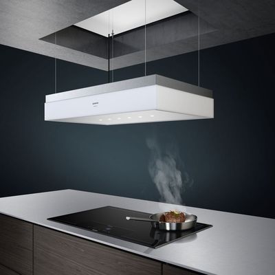Ceiling hood in use over induction hob on kitchen island