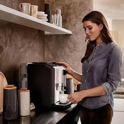 Siemens Coffee World - Una ragazza che prepara una tazza di caffè con una macchina da espresso completamente automatica Siemens EQ.300
