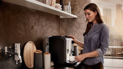 Culture café Siemens - Une jeune femme préparant un café sur une machine à café tout automatique EQ.300 de Siemens.