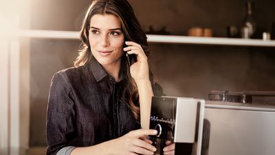 Siemens Coffeeworld - Een vrouw die de stille Siemens EQ.9 volautomatische koffiemachine bedient