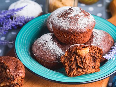 Chocolate muffins on plate with one in half showing inside