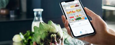 Smart kök: Hand håller mobiltelefon med Home Connect
