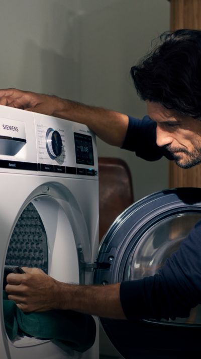 Ein Mann bedient eine Siemens Waschmaschine