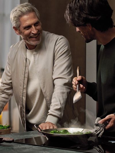 Link öffnet die Übersichtsseite für Siemens Geräte live erleben; zwei Männer beim Kochen mit einem Wok