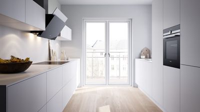 Une cuisine blanche moderne en parallèle dans une pièce lumineuse.