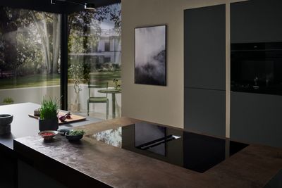 Accogliente zona pranzo con arredamento moderno, tavolo in legno, sedie e elettrodomestici da cucina.