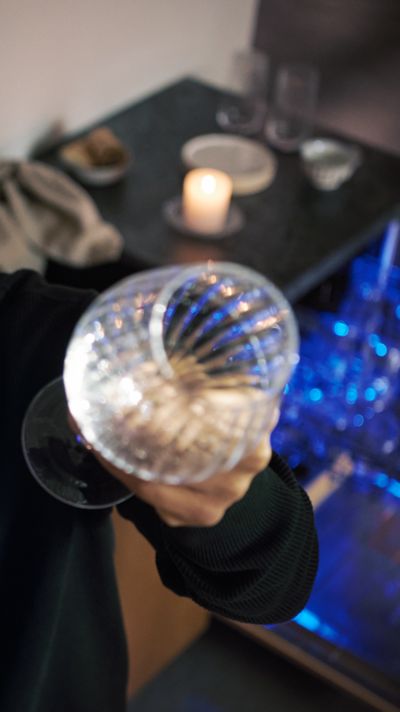 Balle de cristal mystique, bougie et fond sombre avec éclairage bleu, créant une atmosphère spirituelle.